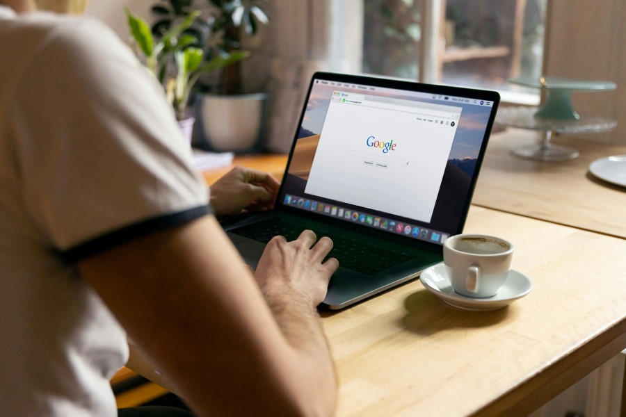 Person using a laptop computer to search Google